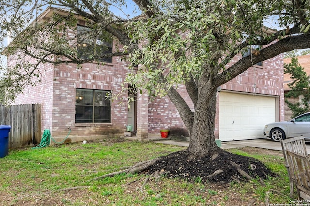 view of side of property with brick siding, concrete driveway, a lawn, an attached garage, and fence