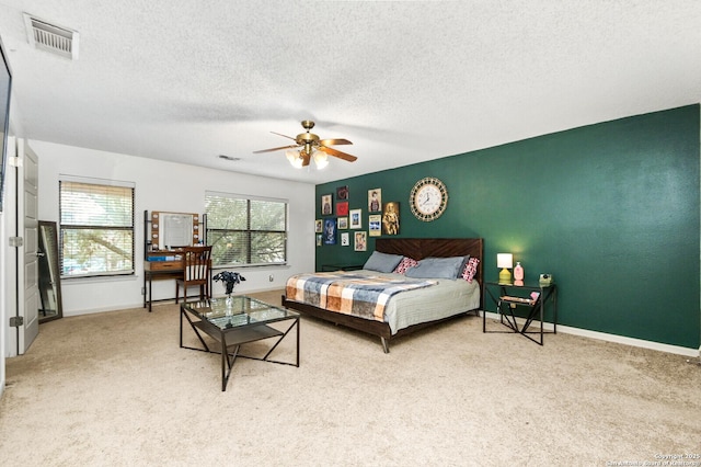 bedroom with carpet, visible vents, a textured ceiling, and baseboards