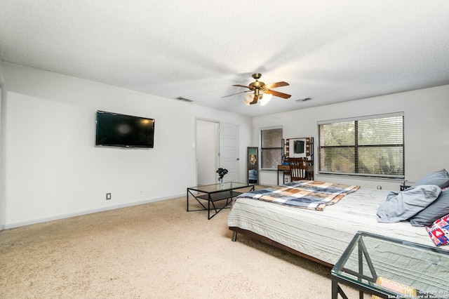bedroom with a textured ceiling, a ceiling fan, visible vents, and baseboards
