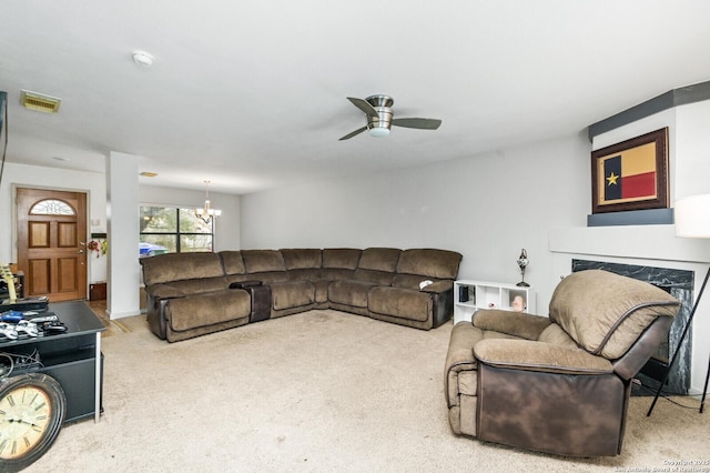 living area with carpet floors, visible vents, a fireplace, and ceiling fan with notable chandelier