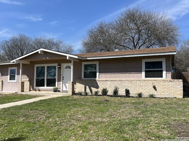 single story home with a front yard, fence, and brick siding