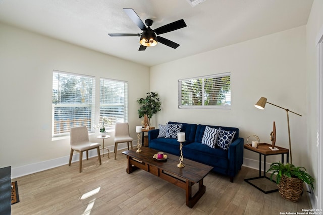 living area featuring light wood finished floors, ceiling fan, and baseboards