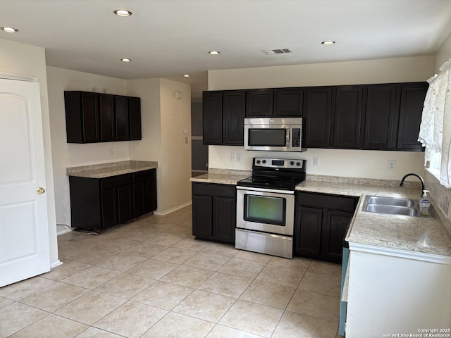 kitchen with light tile patterned floors, a sink, visible vents, light countertops, and appliances with stainless steel finishes