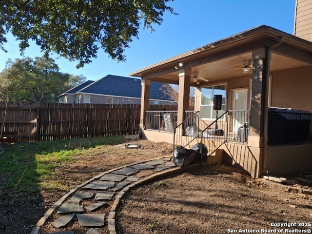 view of yard featuring ceiling fan and a fenced backyard