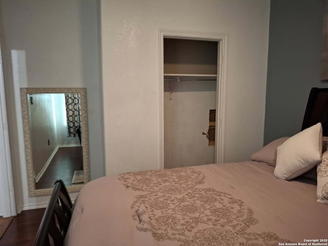 bedroom with dark wood-type flooring and a closet