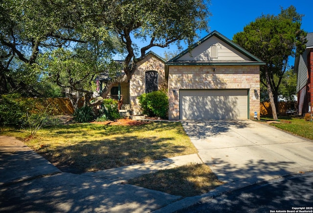 view of front of house featuring stone siding, concrete driveway, fence, and an attached garage