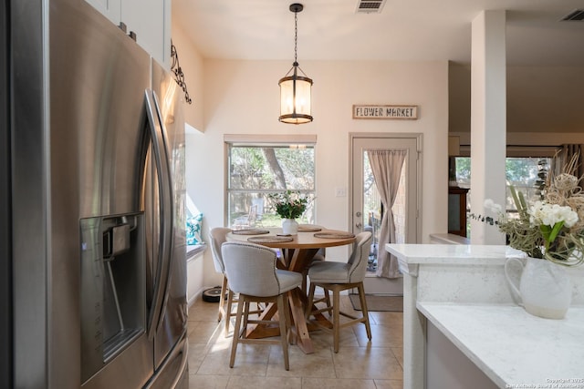 dining area with light tile patterned floors, visible vents, and a wealth of natural light