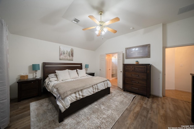 bedroom featuring lofted ceiling, wood finished floors, visible vents, and a ceiling fan