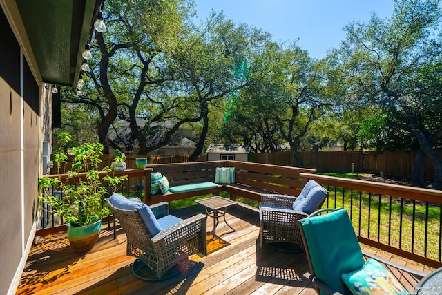 wooden terrace with outdoor lounge area and a fenced backyard