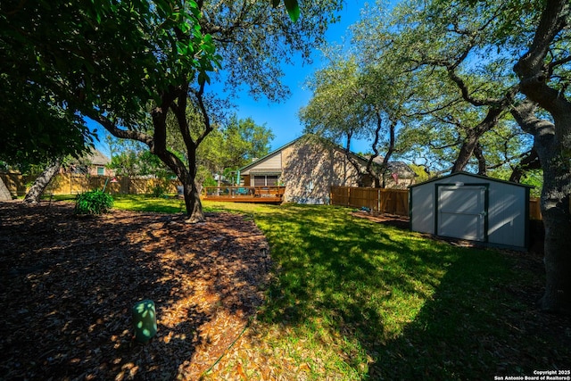 view of yard with a fenced backyard, an outdoor structure, and a storage unit