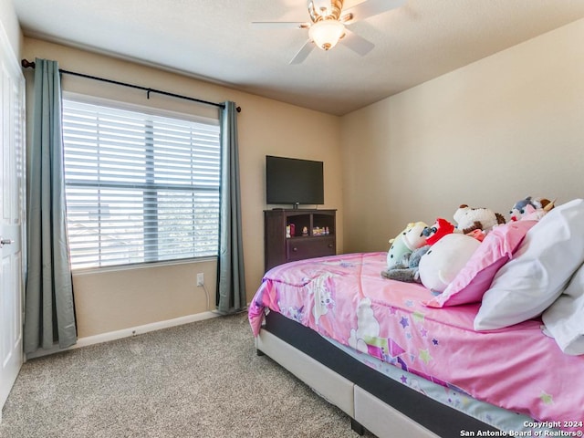 carpeted bedroom with a ceiling fan and baseboards