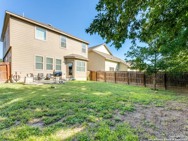 back of house with a yard, a patio, and a fenced backyard