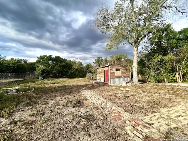 view of yard featuring an outbuilding and fence