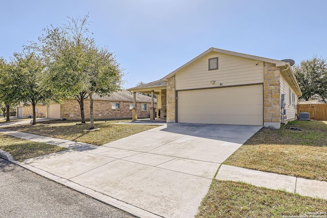 single story home featuring an attached garage, stone siding, driveway, and fence