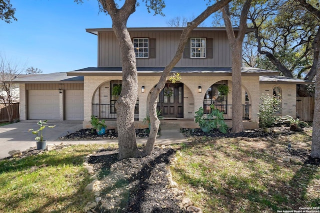 view of front facade featuring a garage, covered porch, brick siding, and concrete driveway