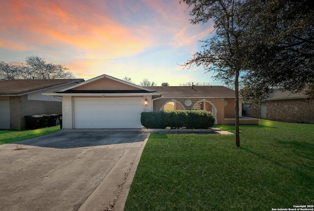 ranch-style home featuring a front yard, driveway, an attached garage, and stucco siding