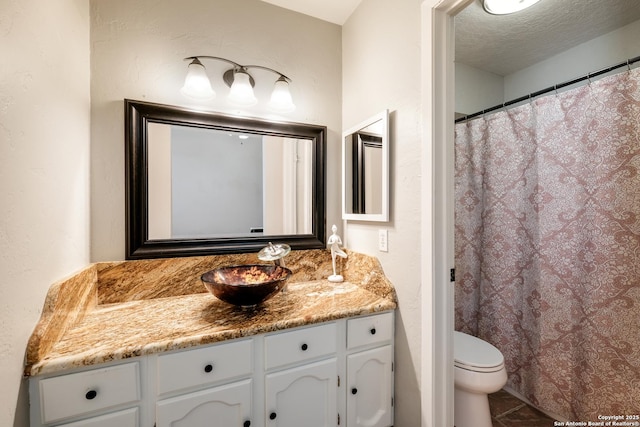 4010 Briarcrest, San Antonio, TX 78247 - bathroom featuring a textured wall, toilet, a textured ceiling, vanity, and tile patterned floors