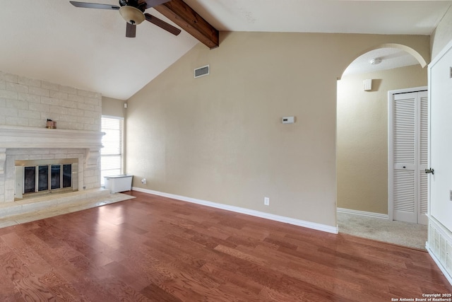 4010 Briarcrest, San Antonio, TX 78247 - unfurnished living room featuring arched walkways, a brick fireplace, wood finished floors, and baseboards