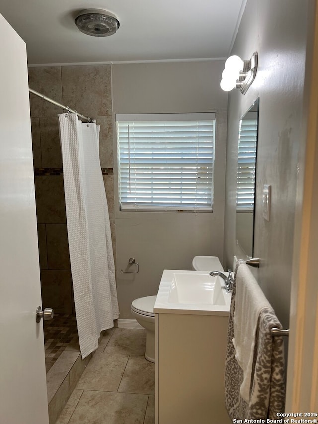 bathroom with tile patterned flooring, a tile shower, vanity, and toilet