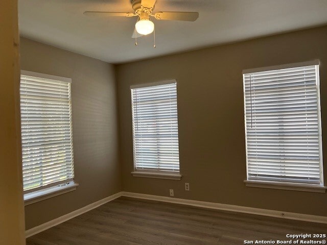 spare room with ceiling fan, wood finished floors, and baseboards