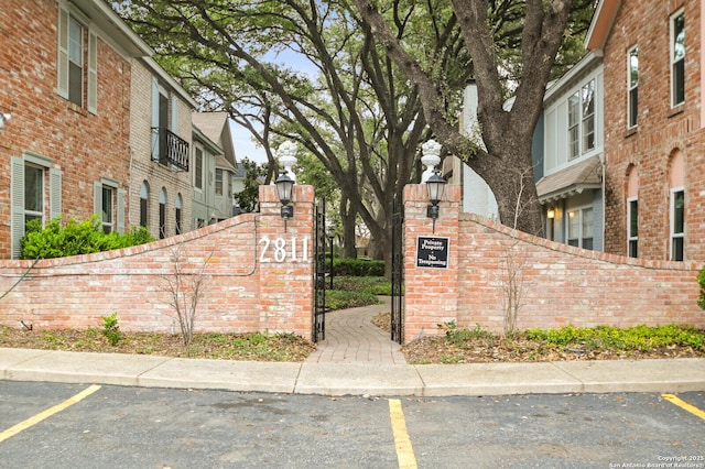 community sign with uncovered parking and a residential view