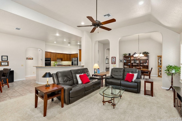 living area featuring arched walkways, lofted ceiling, light colored carpet, ceiling fan with notable chandelier, and visible vents