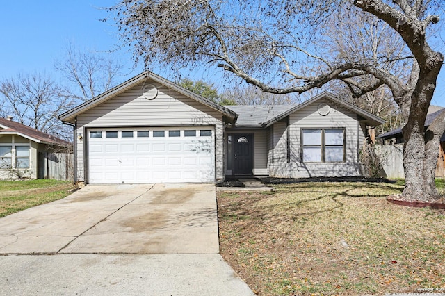 ranch-style home featuring a front yard, concrete driveway, and an attached garage