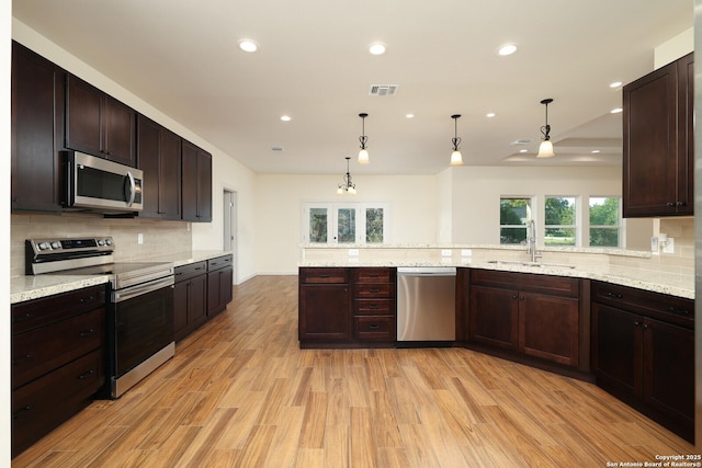 kitchen with light wood-style flooring, a sink, visible vents, appliances with stainless steel finishes, and decorative backsplash