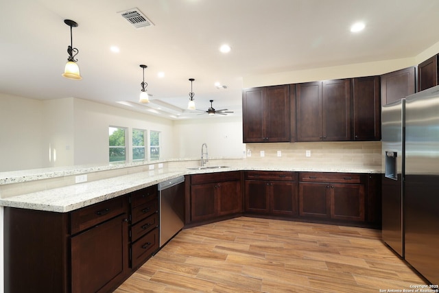 kitchen with stainless steel appliances, a sink, visible vents, light wood-type flooring, and backsplash