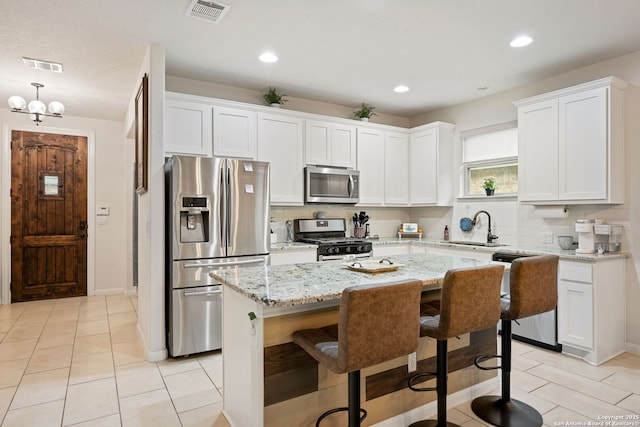 kitchen with stainless steel appliances, tasteful backsplash, a sink, and visible vents