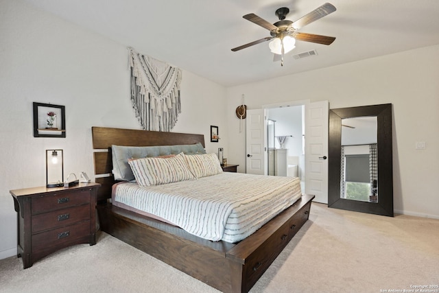 bedroom with ensuite bathroom, light colored carpet, a ceiling fan, baseboards, and visible vents