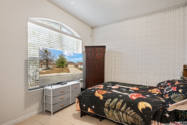 bedroom with light tile patterned flooring and baseboards