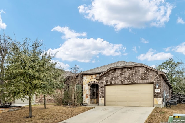 view of front of house with a garage, driveway, brick siding, and stone siding