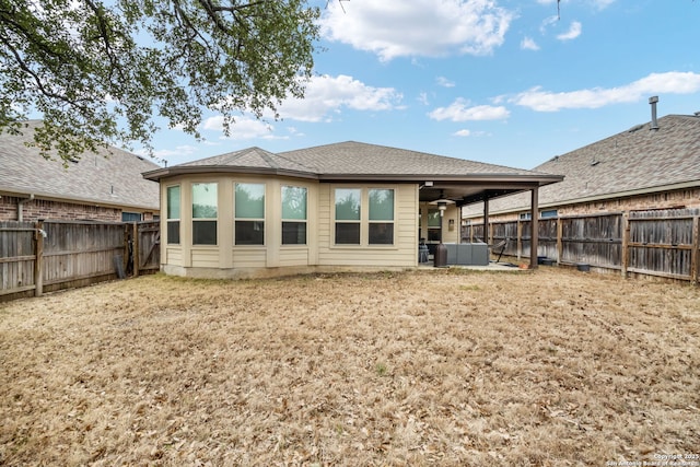 rear view of property featuring a fenced backyard