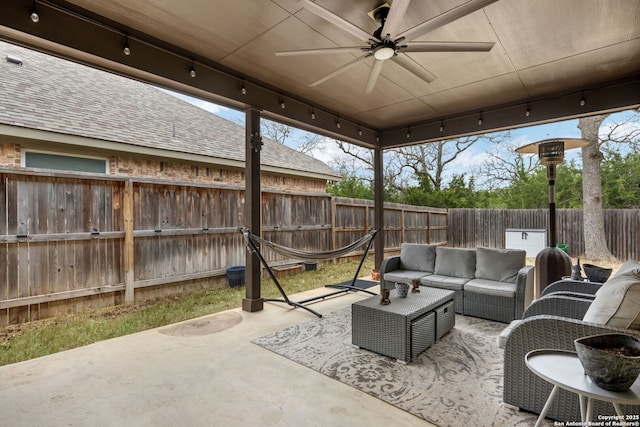 view of patio / terrace featuring a fenced backyard, an outdoor living space, and a ceiling fan