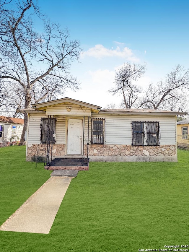 view of front of home with stone siding and a front lawn