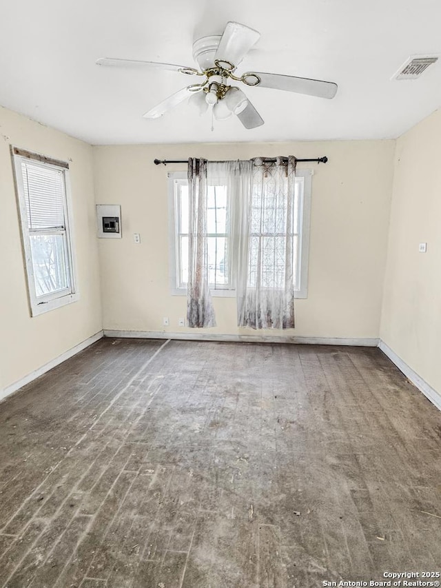 empty room featuring baseboards, visible vents, a ceiling fan, and wood finished floors