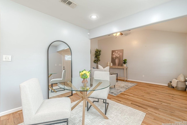 dining space featuring lofted ceiling, light wood finished floors, baseboards, and visible vents