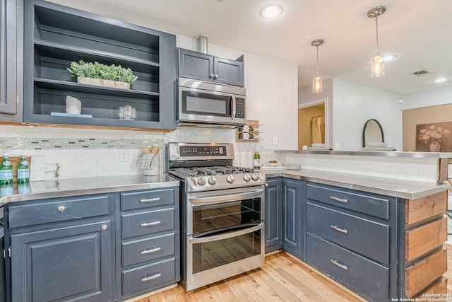 kitchen featuring light wood finished floors, stainless steel appliances, visible vents, decorative backsplash, and a peninsula