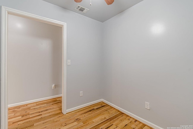 empty room with a ceiling fan, baseboards, visible vents, and wood finished floors