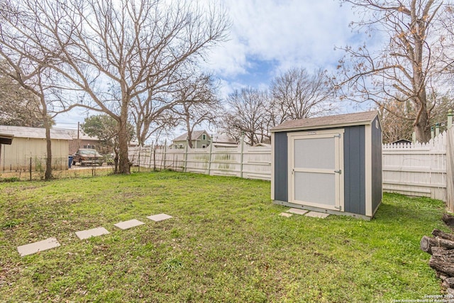view of yard with an outbuilding, a fenced backyard, and a storage unit