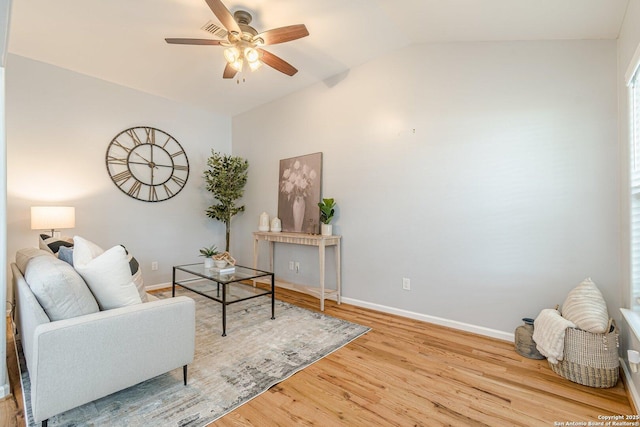 living area with lofted ceiling, ceiling fan, wood finished floors, and baseboards