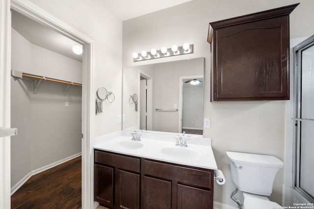 full bathroom with toilet, wood finished floors, a sink, and a shower with shower door