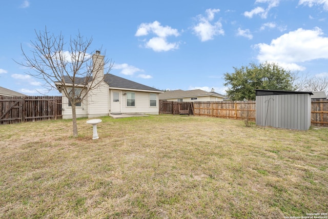 view of yard featuring a fenced backyard, a shed, and an outbuilding