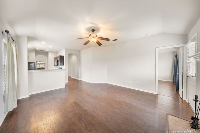 unfurnished living room featuring visible vents, arched walkways, dark wood finished floors, ceiling fan, and vaulted ceiling