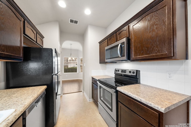 kitchen with visible vents, decorative backsplash, appliances with stainless steel finishes, light countertops, and dark brown cabinets