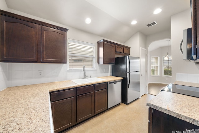 kitchen featuring visible vents, appliances with stainless steel finishes, light countertops, dark brown cabinets, and a sink