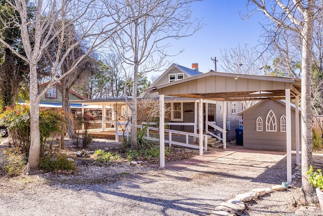 view of front of home featuring driveway, board and batten siding, and a carport