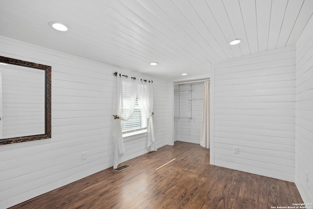 spare room with recessed lighting, visible vents, wood walls, and wood finished floors