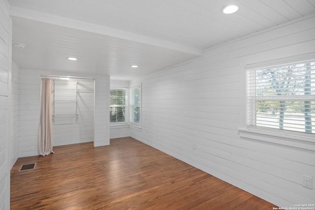 unfurnished room featuring recessed lighting, visible vents, wooden walls, and wood finished floors